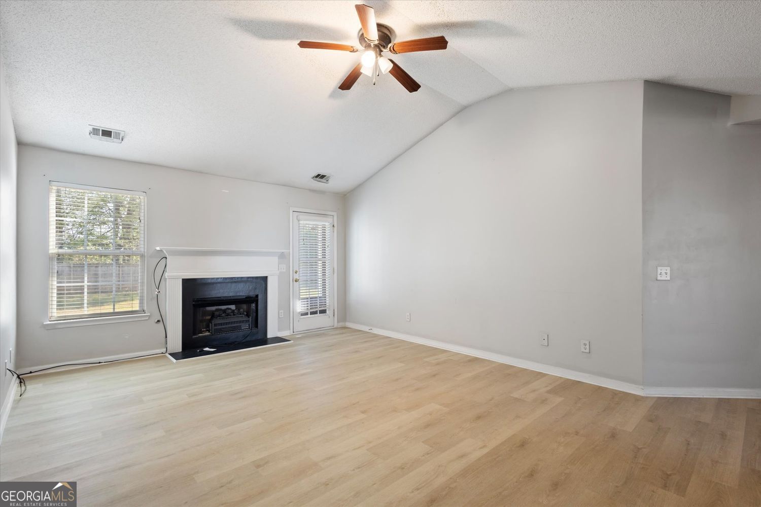 118 Covington Cove Byron, GA 31008 - Photo 11 of 21 an empty room with fireplace and fan