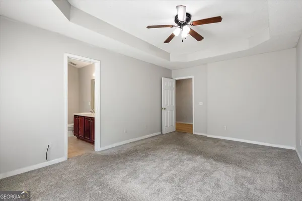 a view of an empty room and chandelier fan