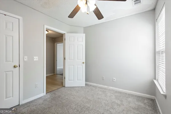 an empty room with windows and closet