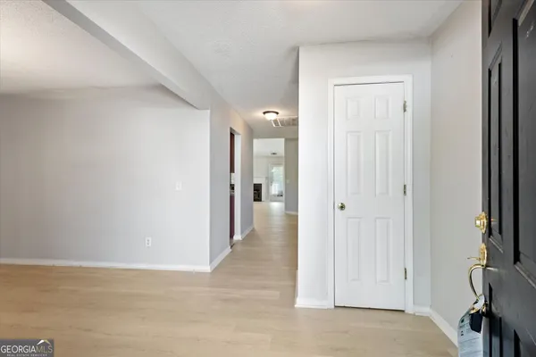 a view of a hallway with closet and a bathroom