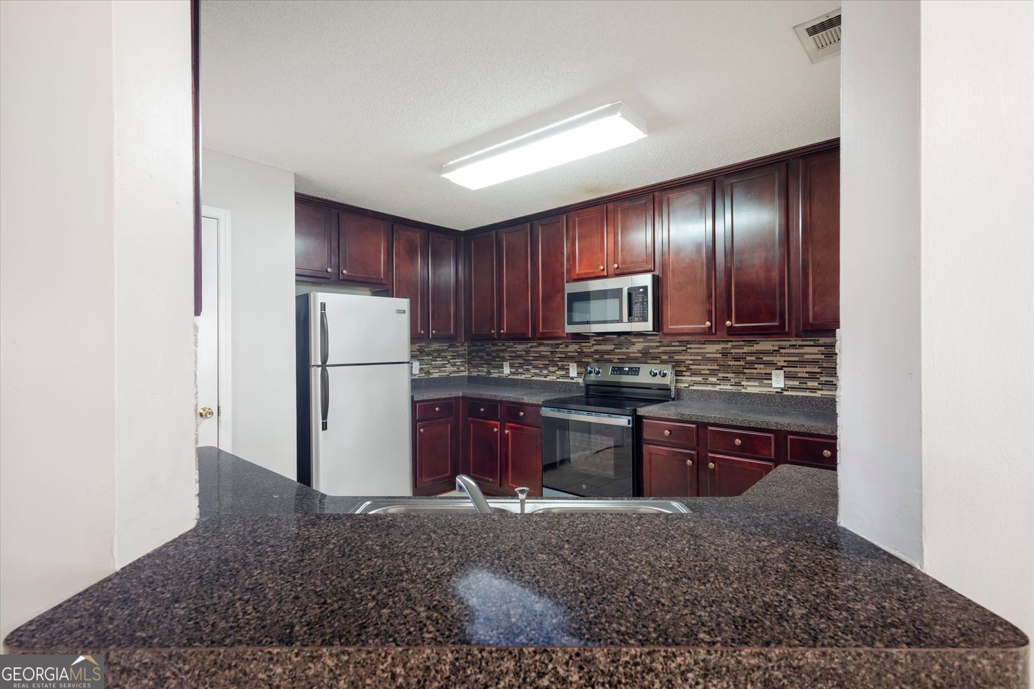 118 Covington Cove Byron, GA 31008 - Photo 10 of 21 a kitchen with stainless steel appliances granite countertop a refrigerator stove and sink