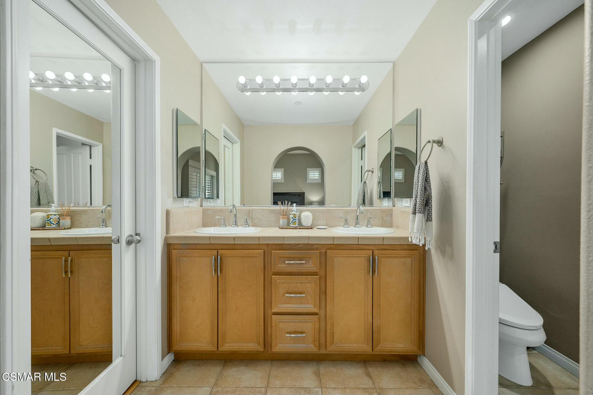 4121 Paredo Way, Unit D Simi Valley, CA 93063 - Photo 14 of 29 a bathroom with a granite countertop sink a toilet and a mirror