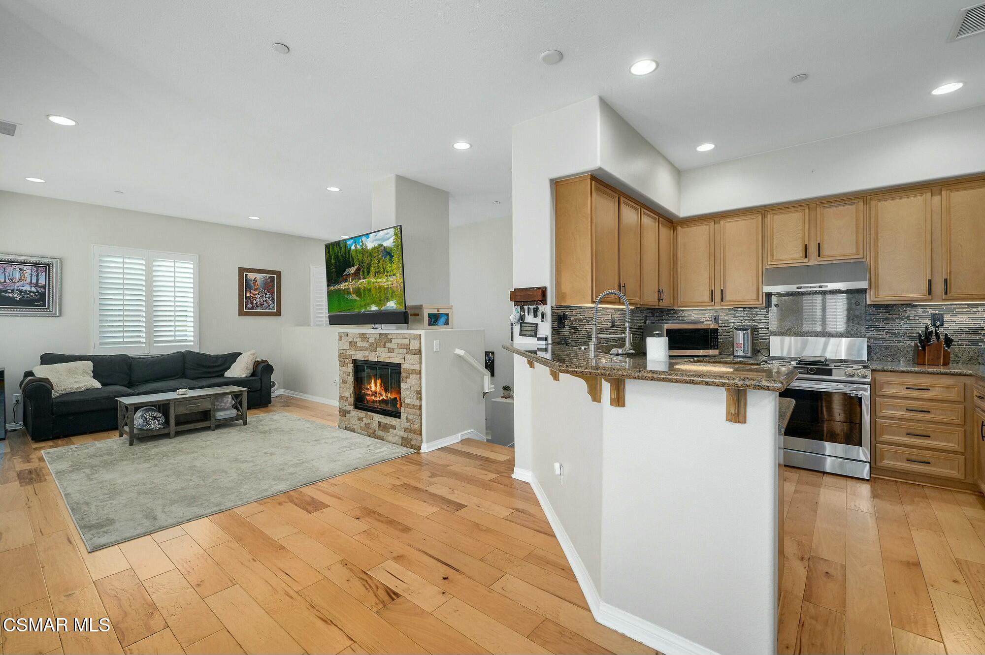 4121 Paredo Way, Unit D Simi Valley, CA 93063 - Photo 4 of 29 a kitchen with stainless steel appliances granite countertop a refrigerator stove microwave and sink