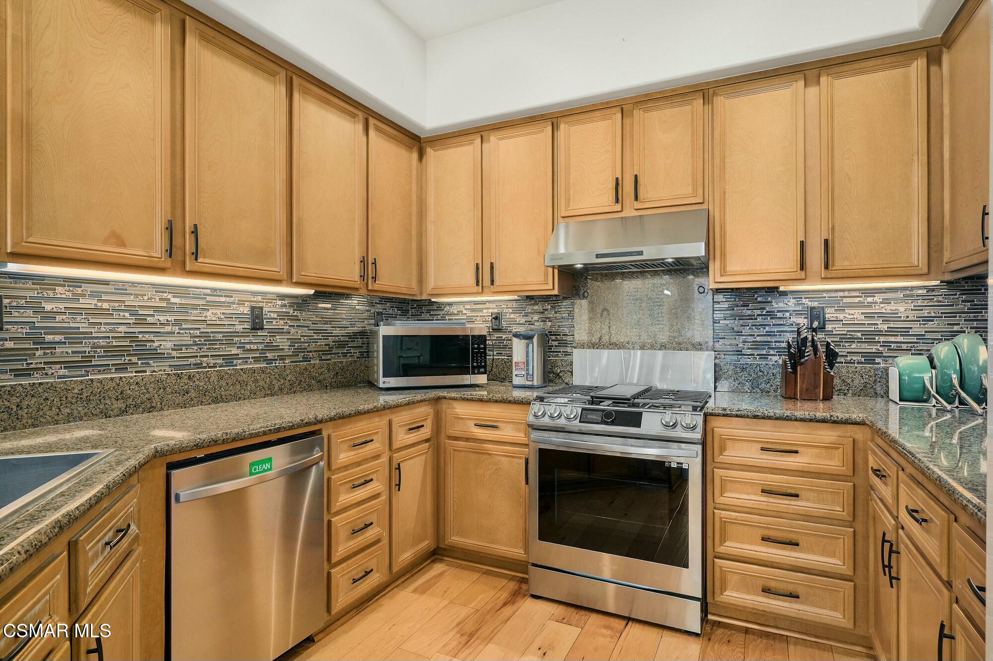 4121 Paredo Way, Unit D Simi Valley, CA 93063 - Photo 8 of 29 a kitchen with stainless steel appliances granite countertop a stove a sink and a microwave