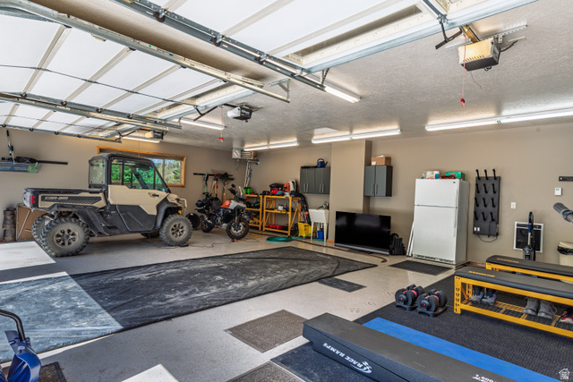 401 North Aoki Michi Road Brian Head, UT 84719 - Photo 47 of 58 Three-car garage with overhead lighting, a utility sink, built-in cabinetry, and a window