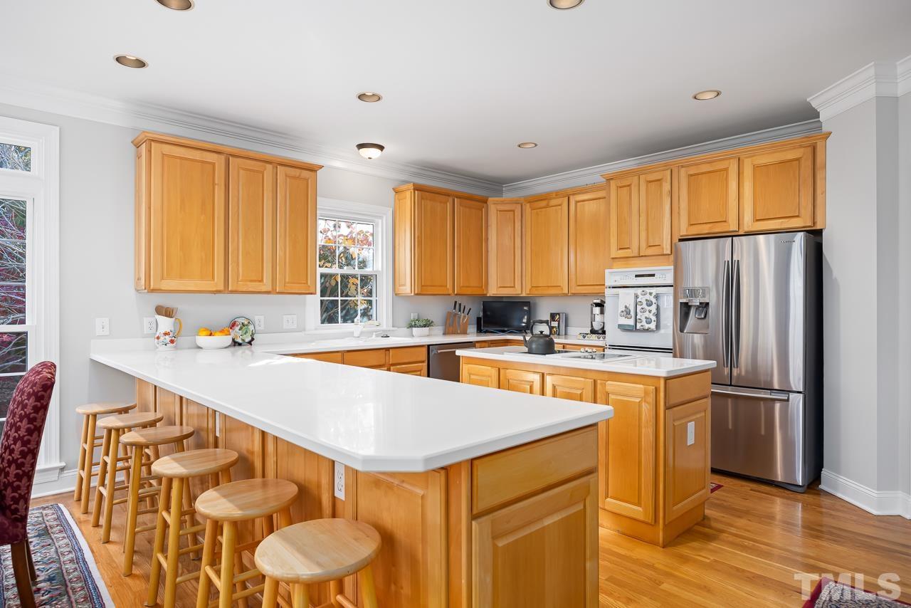 8712 Bell Grove Way Raleigh, NC 27615 - Photo 16 of 42 a kitchen with stainless steel appliances a sink a stove a refrigerator cabinets and a window