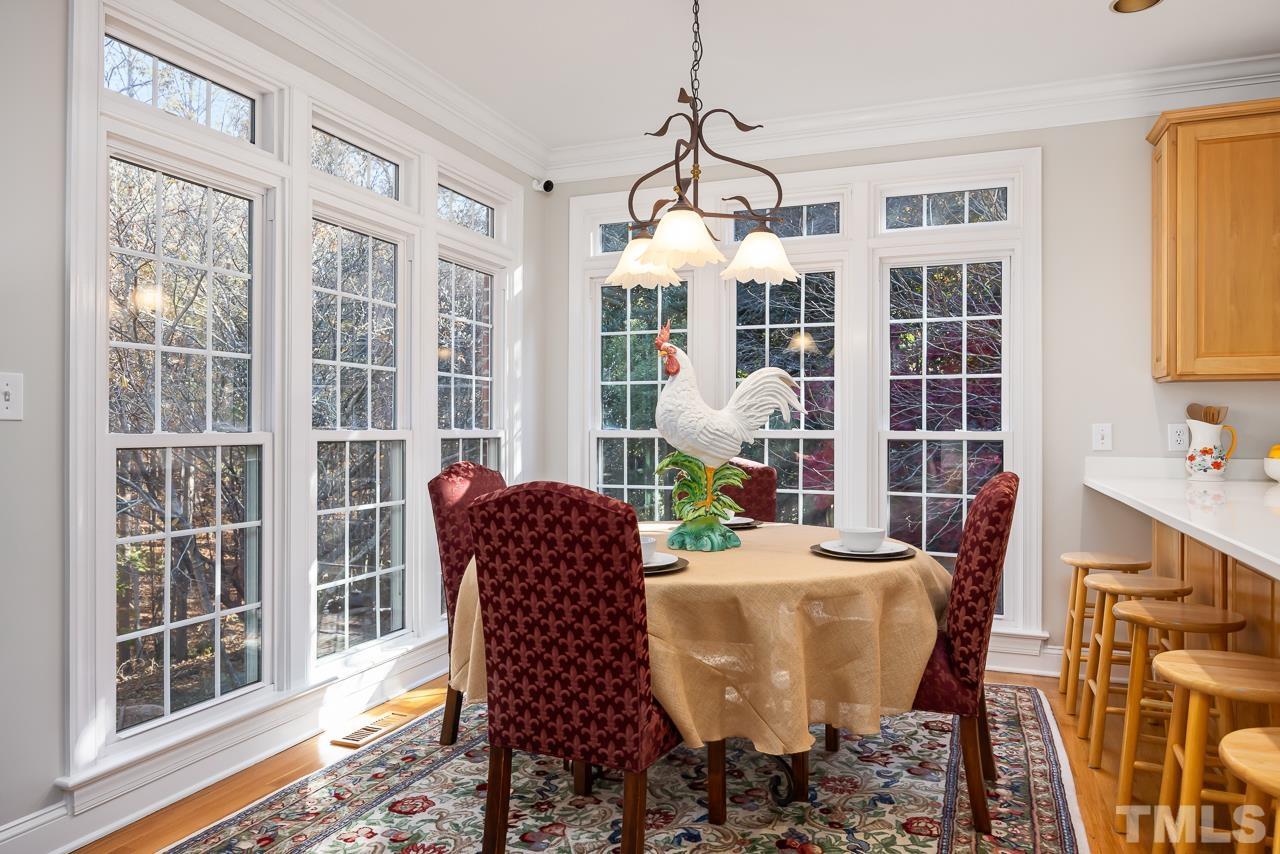 8712 Bell Grove Way Raleigh, NC 27615 - Photo 19 of 42 a dining room with furniture a chandelier and wooden floor