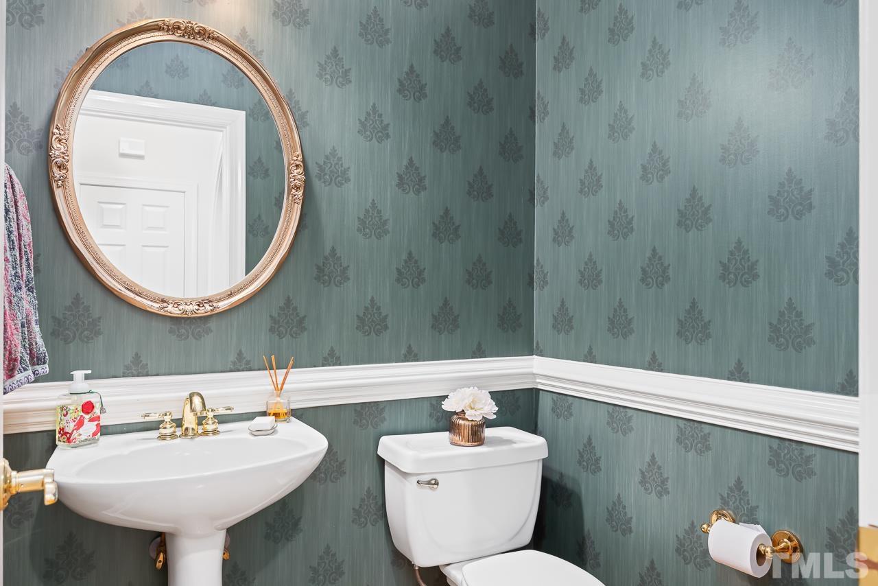 8712 Bell Grove Way Raleigh, NC 27615 - Photo 22 of 42 a bathroom with a sink a mirror and a toilet