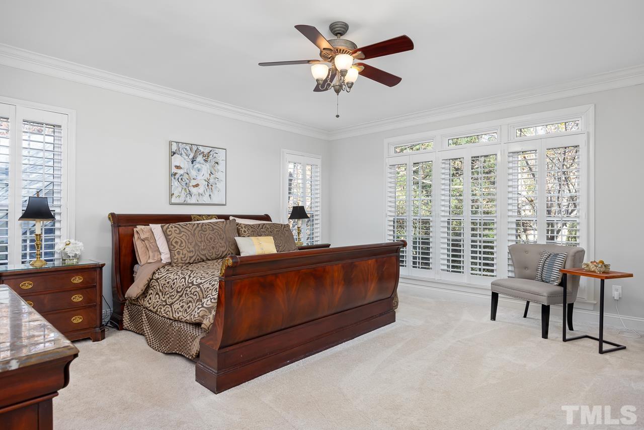 8712 Bell Grove Way Raleigh, NC 27615 - Photo 23 of 42 a bedroom with a bed and a chandelier