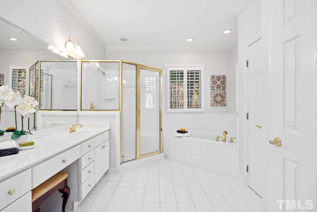 8712 Bell Grove Way Raleigh, NC 27615 - Photo 24 of 42 a spacious bathroom with a double vanity sink a large mirror and shower