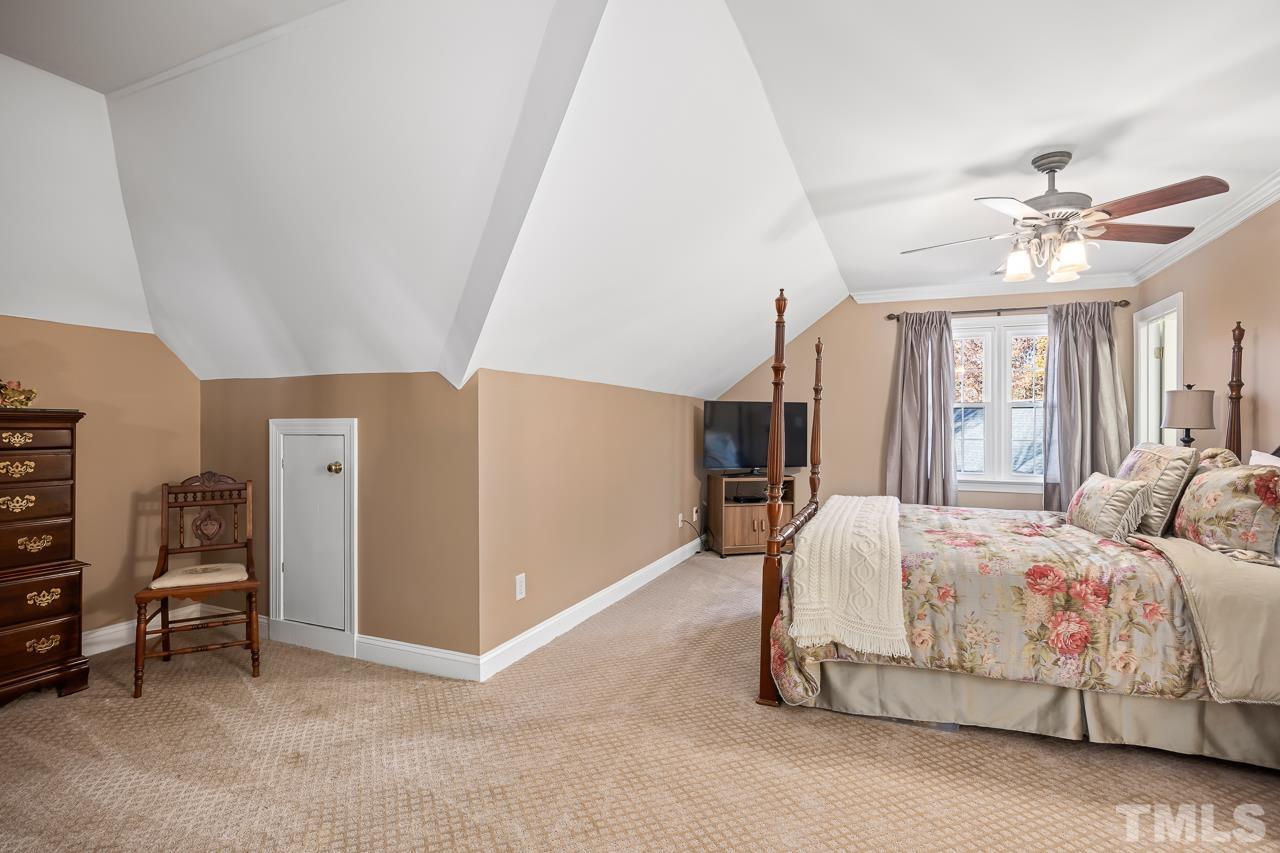 8712 Bell Grove Way Raleigh, NC 27615 - Photo 26 of 42 a spacious bedroom with a bed and a chandelier
