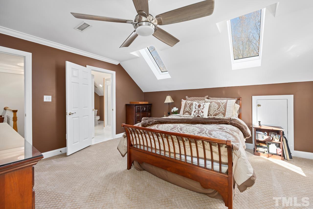 8712 Bell Grove Way Raleigh, NC 27615 - Photo 30 of 42 a bedroom with a bed and a chandelier