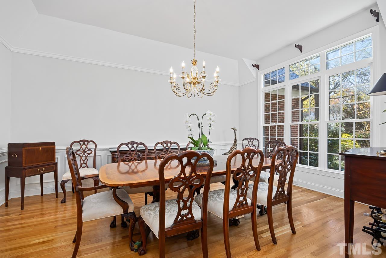 8712 Bell Grove Way Raleigh, NC 27615 - Photo 9 of 42 a view of a dining room with furniture a chandelier and wooden floor