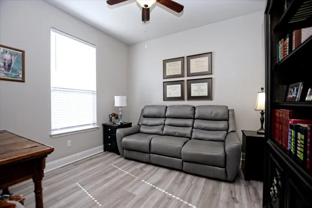 a living room with furniture a flat screen tv and a window