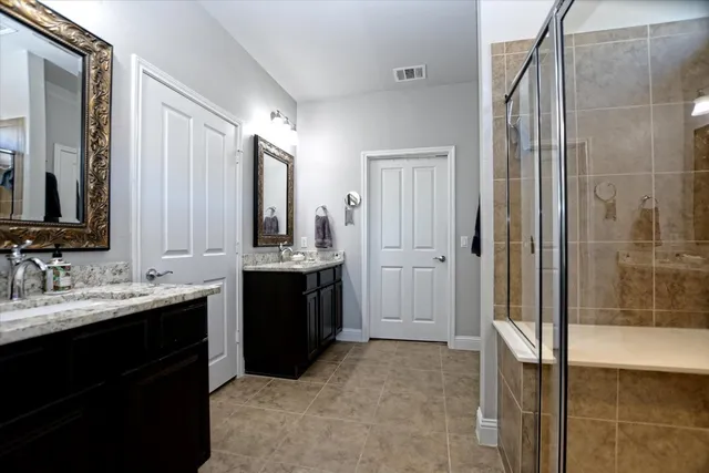a bathroom with a double vanity sink a mirror and shower
