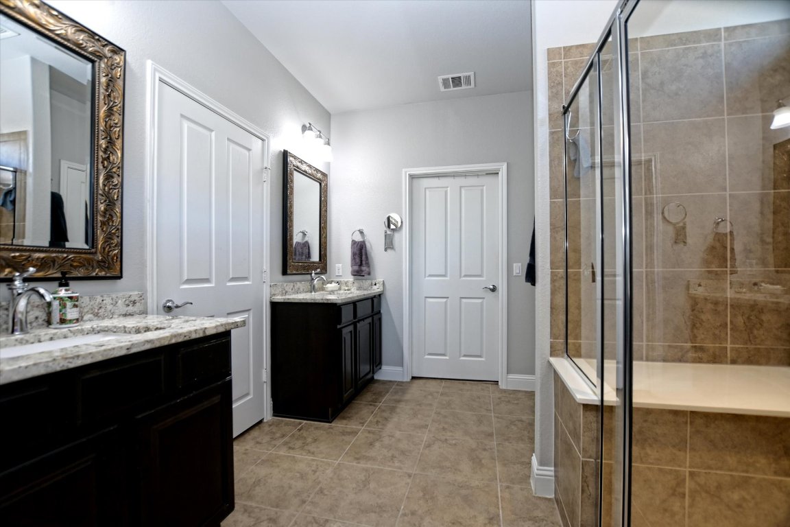 113 Cathedral Mountain Pass Georgetown, TX 78633 - Photo 19 of 29 a bathroom with a double vanity sink a mirror and shower