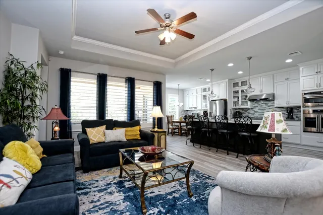 a living room with furniture kitchen view and a potted plant