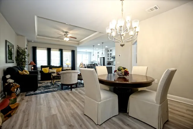 a living room with dining table and a chandelier