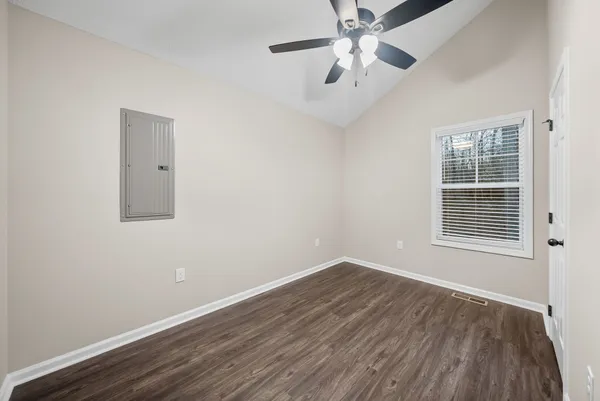 an empty room with a window and a ceiling fan