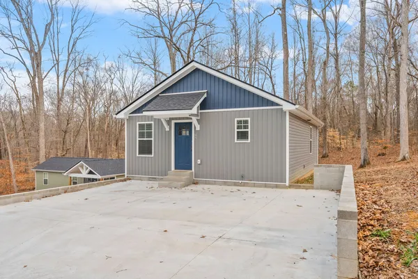 a front view of house with yard and trees around