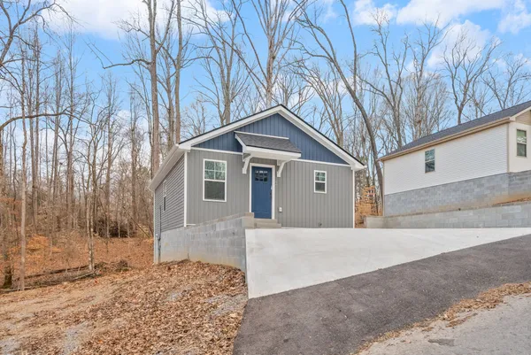 a front view of a house with a yard covered in snow