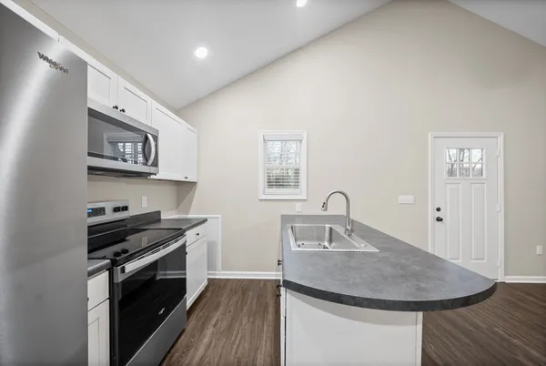 a kitchen with stainless steel appliances granite countertop a sink stove and cabinets