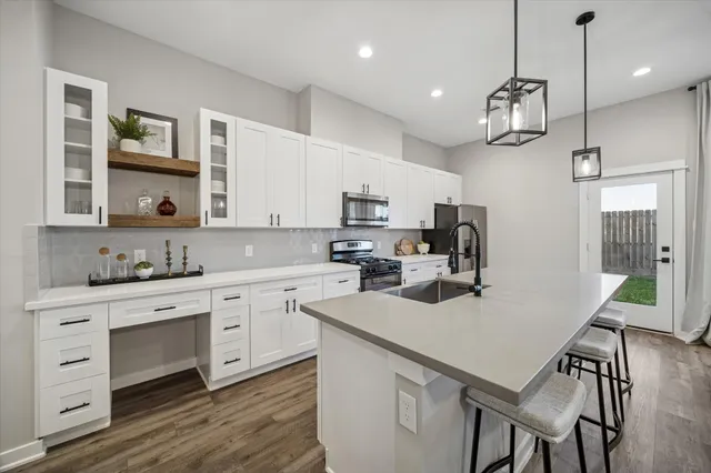 a kitchen with a center island white cabinets and stainless steel appliances