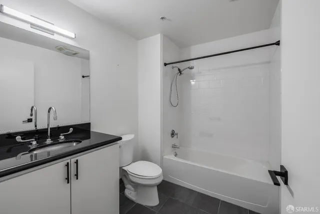 a bathroom with a sink a toilet a mirror and shower