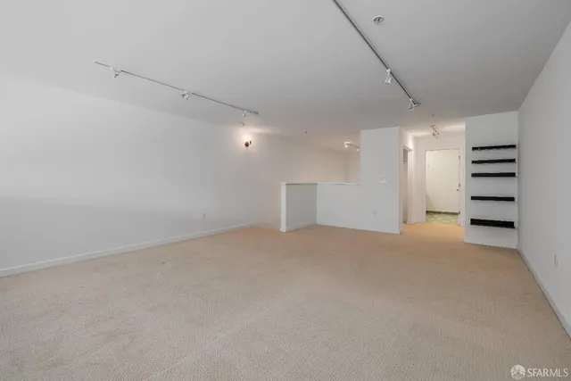 a view of an empty room with a kitchen