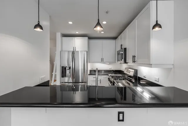 a kitchen with kitchen island a sink stainless steel appliances and cabinets