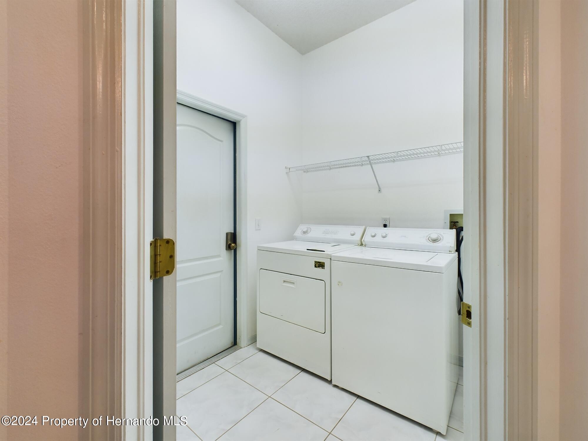 9198 Elida Road Spring Hill, FL 34608 - Photo 26 of 40 a utility room with cabinets washer and dryer