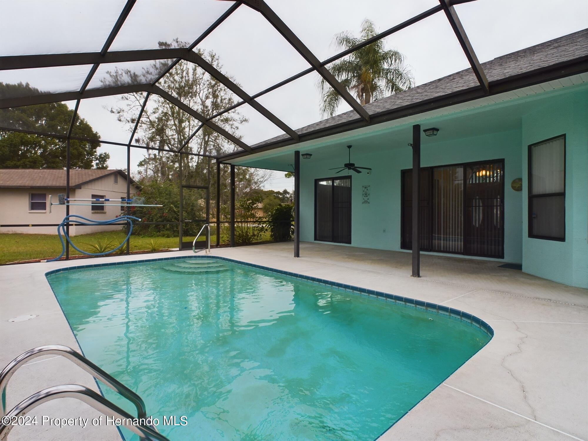 9198 Elida Road Spring Hill, FL 34608 - Photo 30 of 40 a view of a swimming pool with a patio