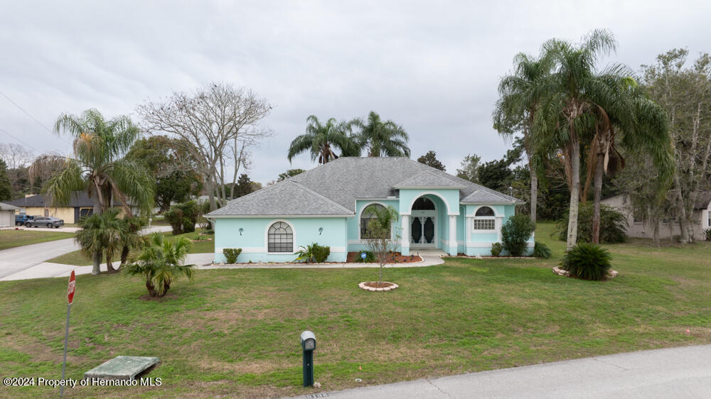 9198 Elida Road Spring Hill, FL 34608 - Photo 3 of 40 a front view of a house with a yard
