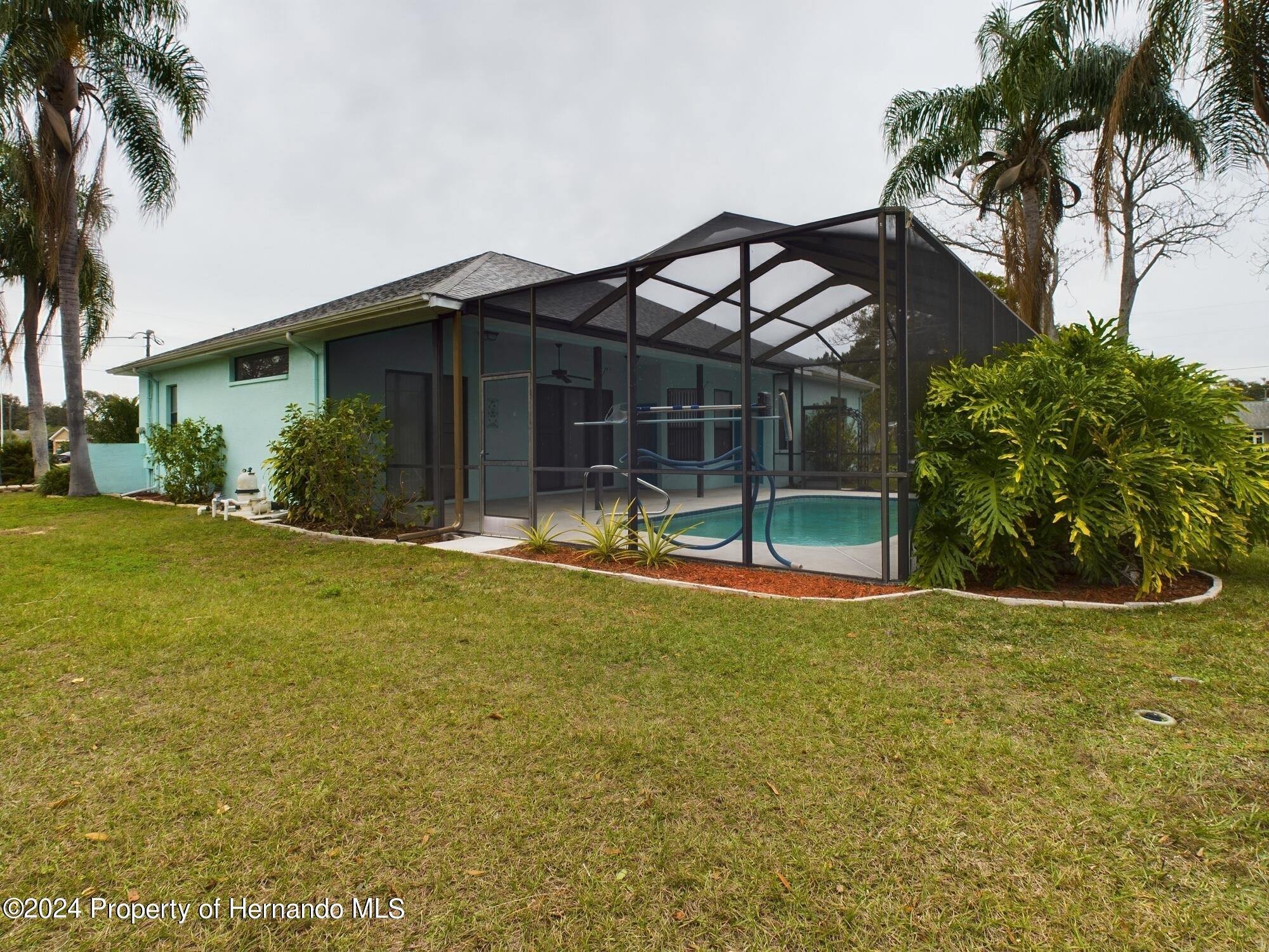 9198 Elida Road Spring Hill, FL 34608 - Photo 5 of 40 a view of a house with patio and a garden