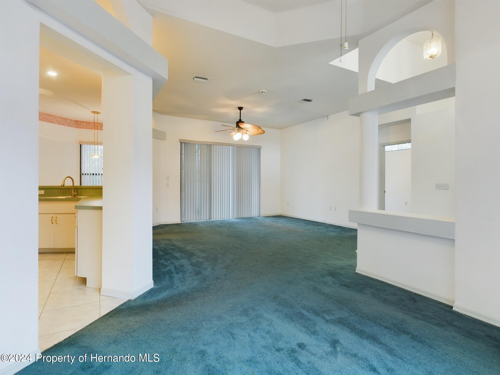 9198 Elida Road Spring Hill, FL 34608 - Photo 6 of 40 a view of a hallway with wooden floor and a kitchen