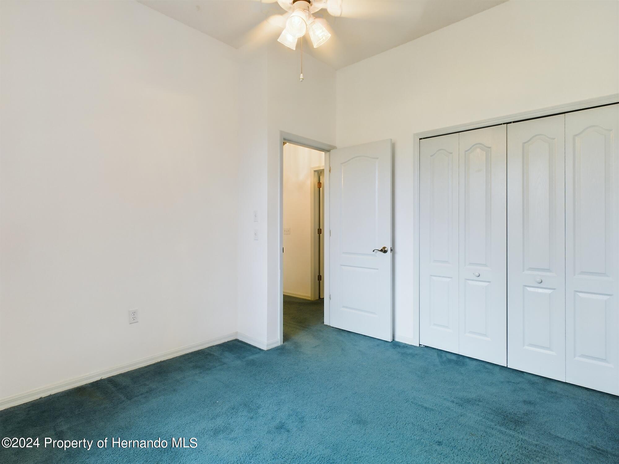 9198 Elida Road Spring Hill, FL 34608 - Photo 7 of 40 a view of an empty room with a ceiling fan