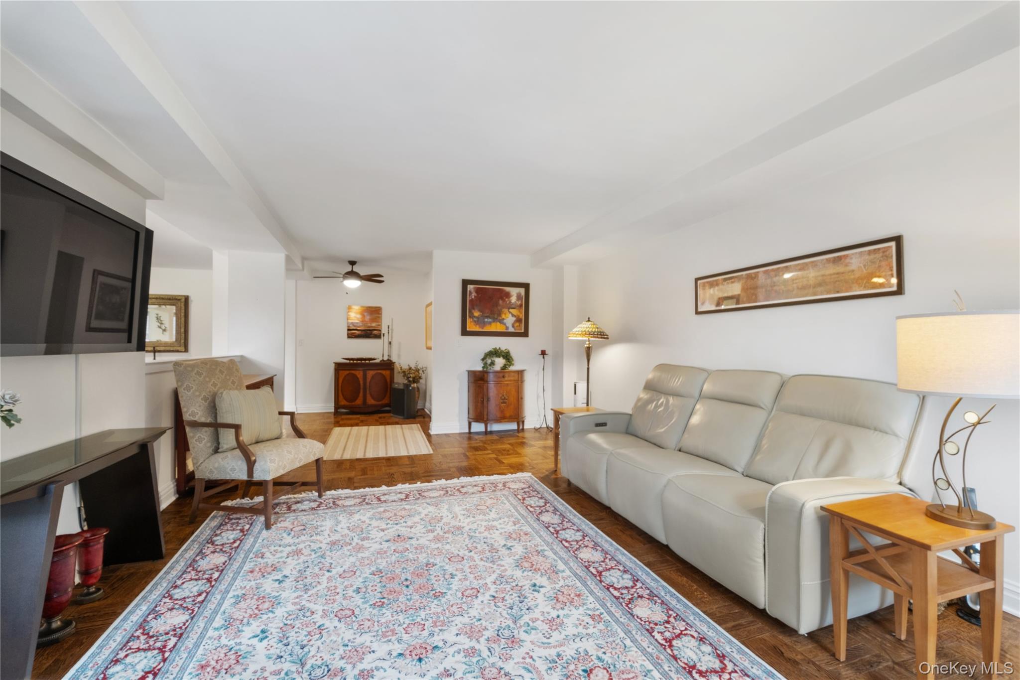 235 Garth Road, Unit E2A Scarsdale, NY 10583 - Photo 17 of 37 a living room with furniture and a flat screen tv