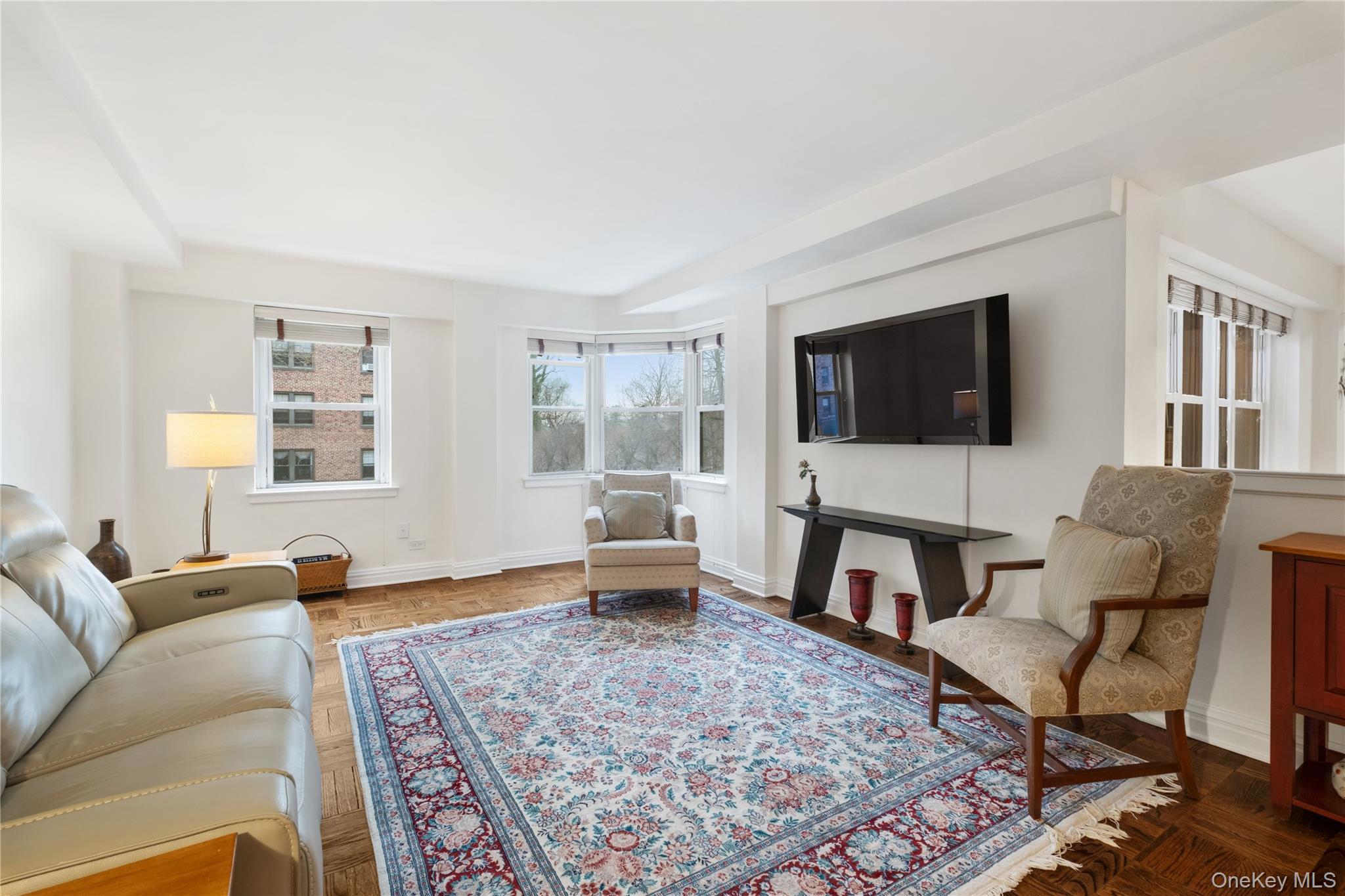 235 Garth Road, Unit E2A Scarsdale, NY 10583 - Photo 18 of 37 a living room with furniture and a flat screen tv