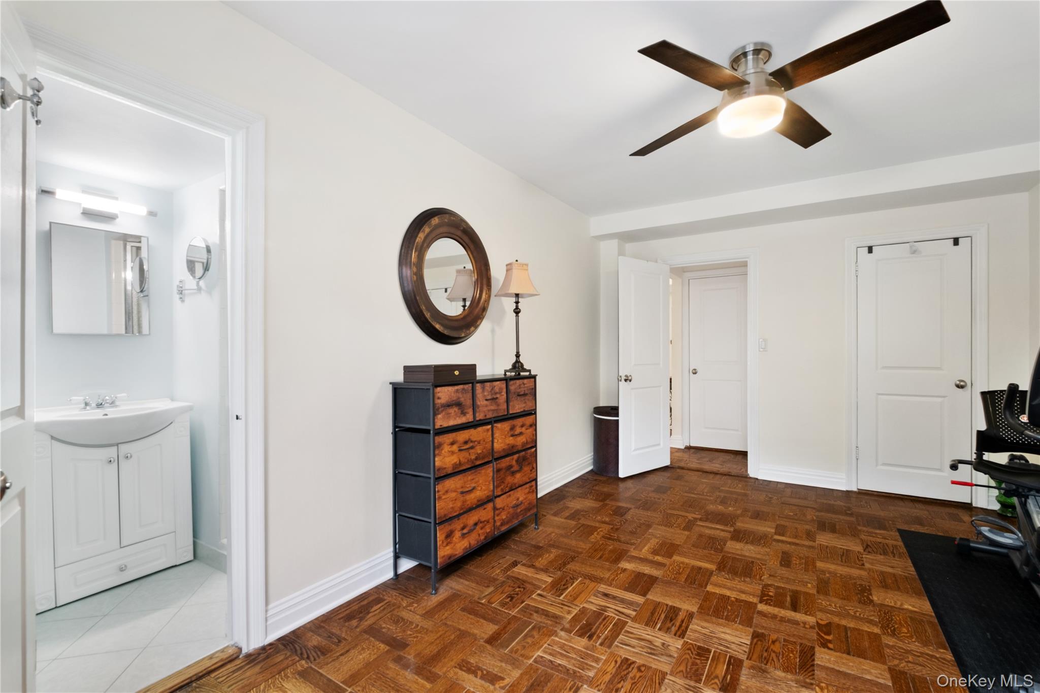 235 Garth Road, Unit E2A Scarsdale, NY 10583 - Photo 25 of 37 a bedroom with a bed and a chandelier