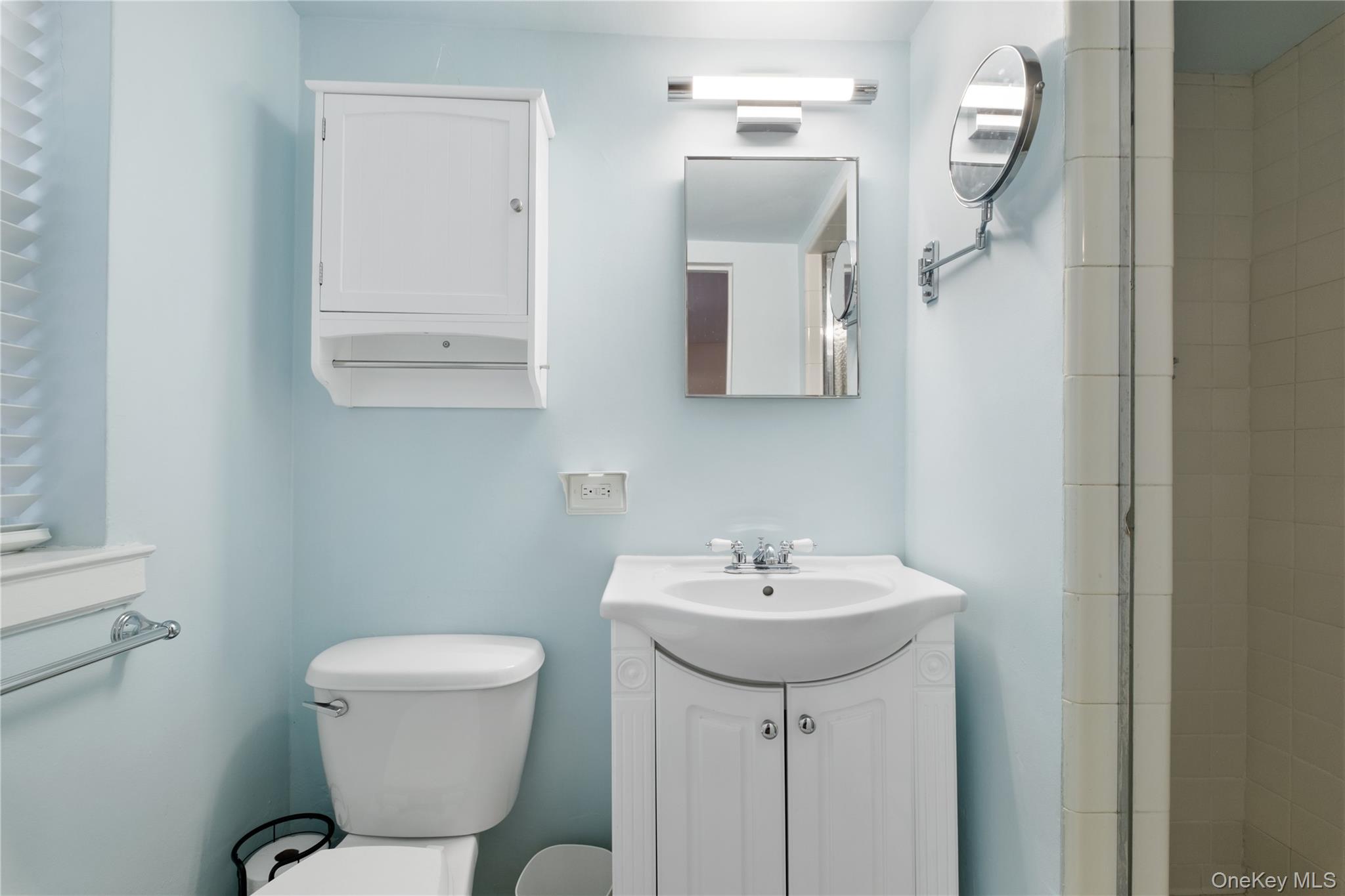 235 Garth Road, Unit E2A Scarsdale, NY 10583 - Photo 27 of 37 a bathroom with a toilet sink and mirror