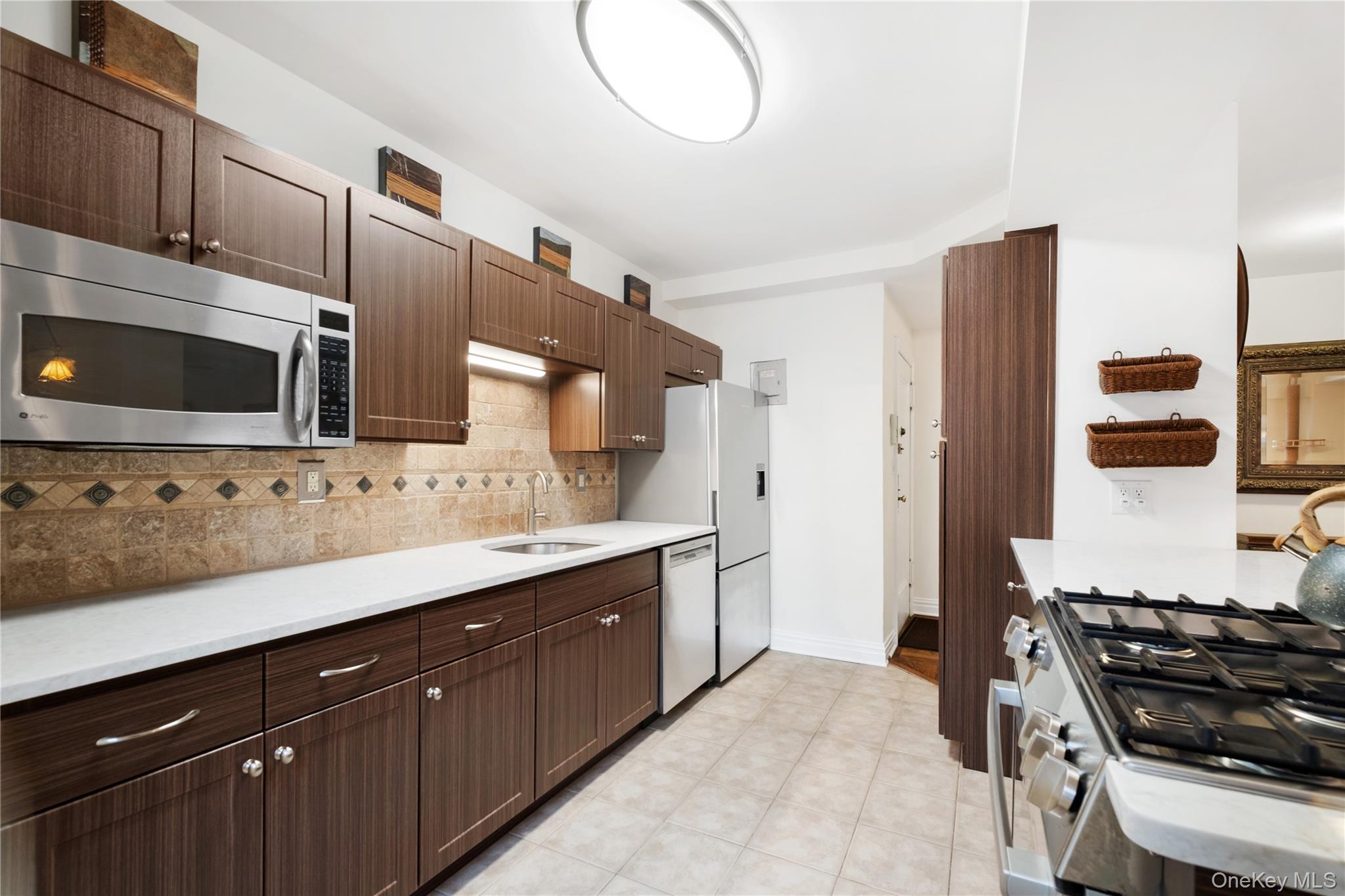 235 Garth Road, Unit E2A Scarsdale, NY 10583 - Photo 3 of 37 a kitchen with stainless steel appliances a stove and a microwave