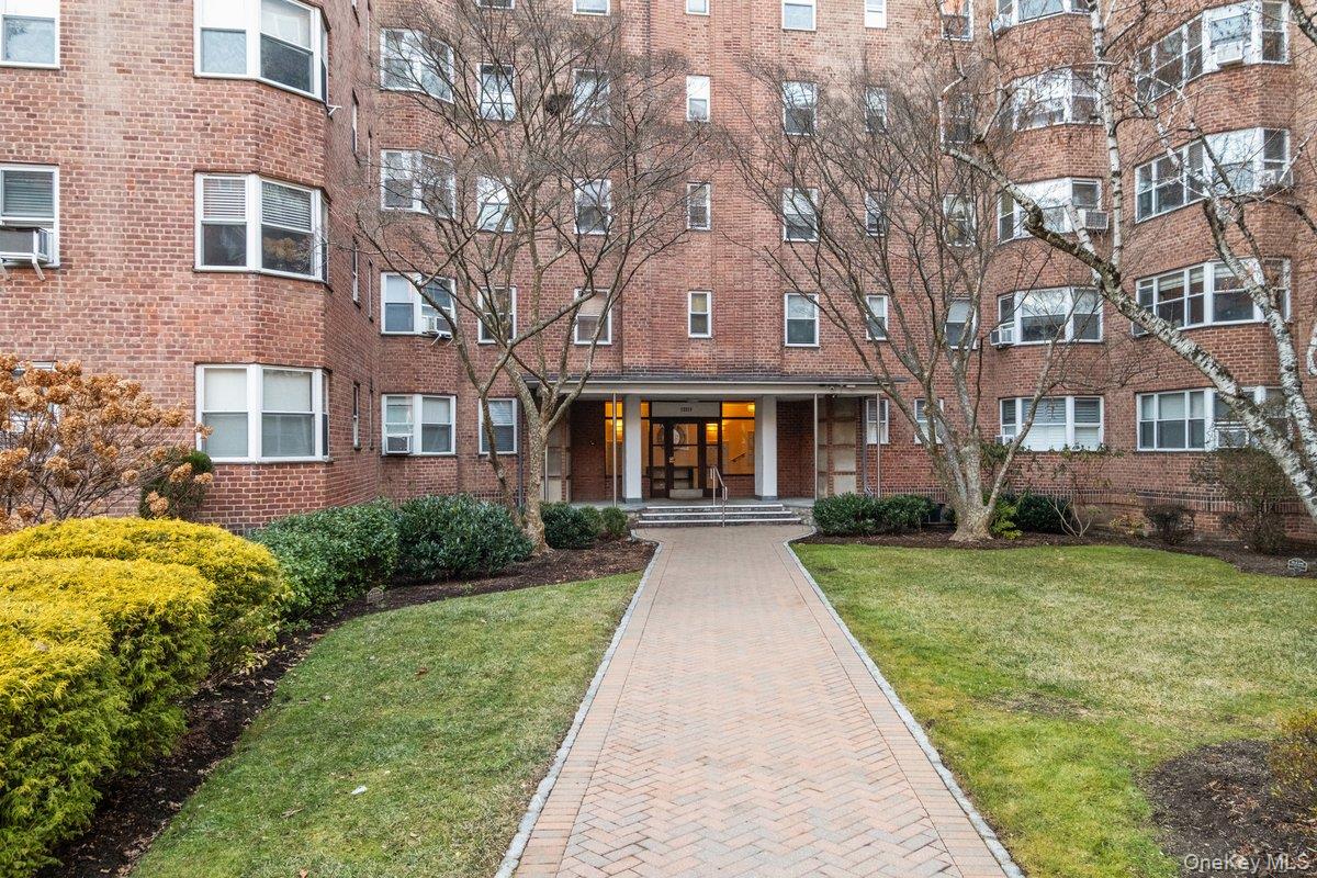 235 Garth Road, Unit E2A Scarsdale, NY 10583 - Photo 31 of 37 a front view of a building with garden