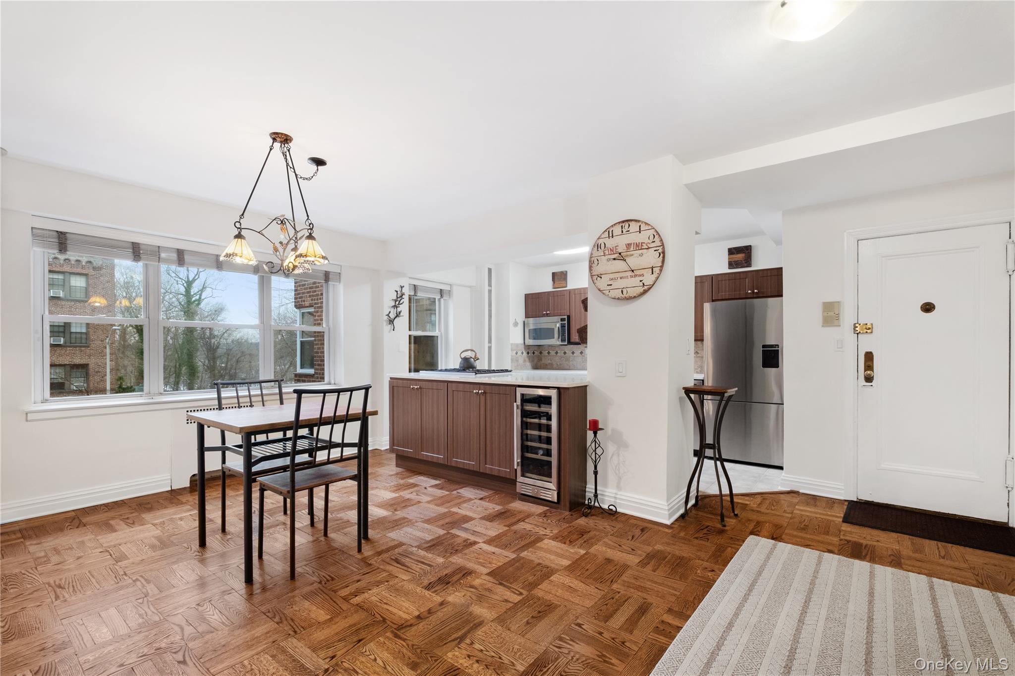 235 Garth Road, Unit E2A Scarsdale, NY 10583 - Photo 6 of 37 a dining room with furniture a chandelier and wooden floor