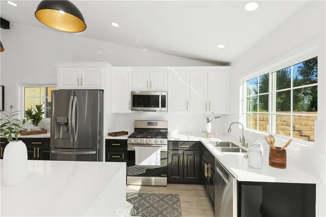 a kitchen with stainless steel appliances granite countertop a sink stove and refrigerator