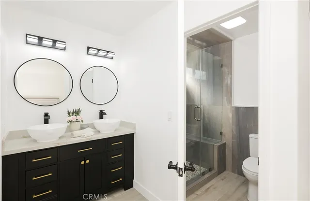 a bathroom with a double vanity sink mirror and toilet
