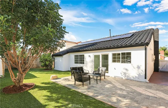 a view of a house with backyard and a sitting area