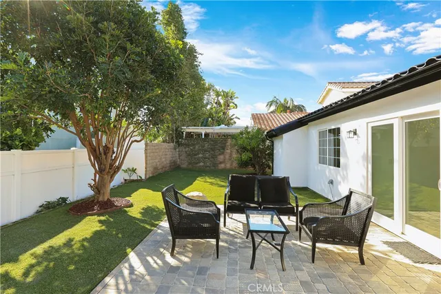 a backyard of a house with table and chairs