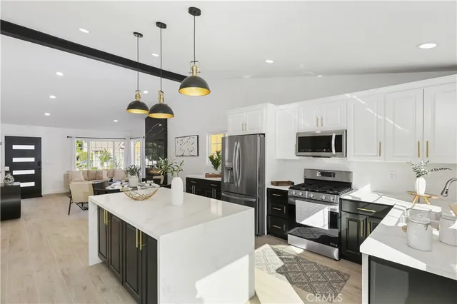 a kitchen with a sink a counter top space stainless steel appliances and cabinets