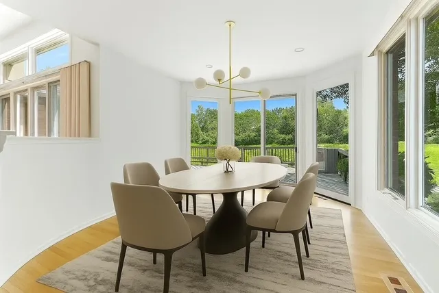 a view of a big room with windows and chandelier fan