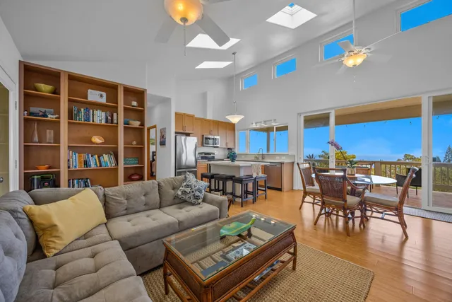 a living room with furniture kitchen view and a large window